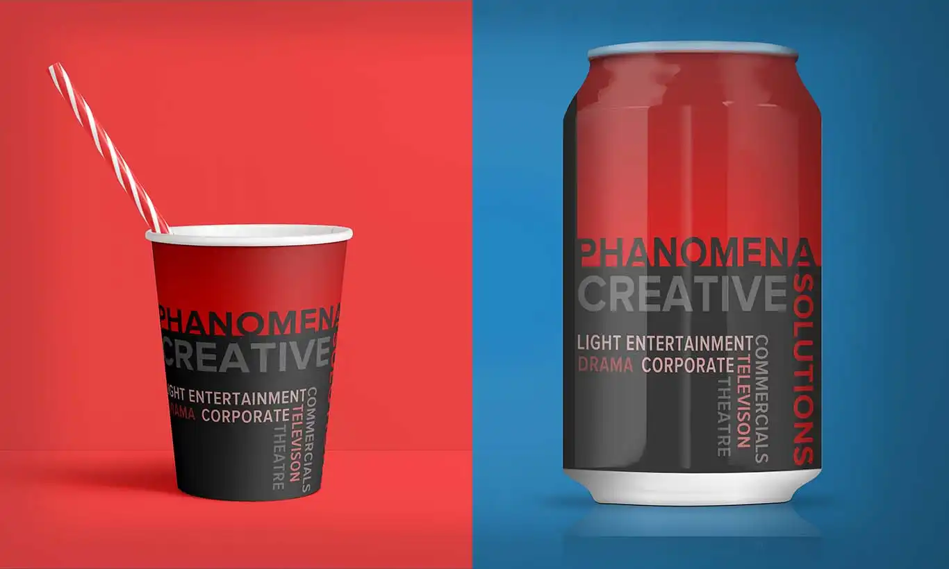 Phanomena-Exhibition-Merchandise-Design-Can-and-Cup The image showcases a red and black disposable cup with a striped straw on a matching red background, and a red and black soda can on a contrasting blue background. Both items, featuring the text "PHANOMENA CREATIVE SOLUTIONS" alongside words like "drama," "corporate," and "entertainment," highlight the brand's striking merchandise design.